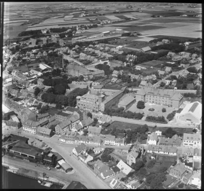 Luftfoto af Thisted. Det Kongelige Bibliotek. Sylvest Jensen, 1956. Havn, kulhandel, Gymnasiet, Grønningen, Sygehus